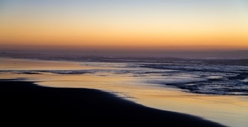 Ein Strand mit Wellen und Sonnenuntergang