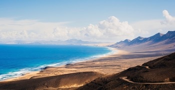 Ein Strand mit Bergen im Hintergrund