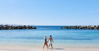 un hombre y una mujer paseando por una playa